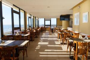 サンベルナルドにあるHostal del Solのテーブルと椅子、窓のあるレストラン