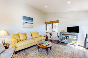 ein Wohnzimmer mit einem gelben Sofa und einem Kamin in der Unterkunft Panoramic Ocean View Home in Elk with Beach Access in Elk
