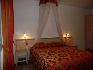 a bedroom with a bed with a canopy and two lights at La Piccola Corte in Alberobello