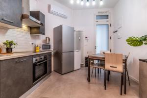 uma cozinha com uma mesa e um frigorífico de aço inoxidável em Tartini Lofts em Bolonha