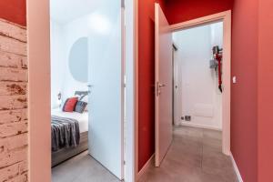 uma sala com paredes vermelhas e uma porta que leva a um quarto em Tartini Lofts em Bolonha