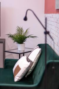 um sofá verde com uma mesa e um vaso de plantas em Tartini Lofts em Bolonha