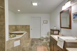 a bathroom with a tub and a toilet and a sink at 7 Mi to French Quarter NOLA Abode with Home Theater in New Orleans +20 photos