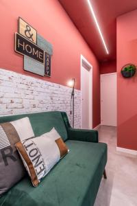 uma sala de estar com um sofá verde e uma parede vermelha em Tartini Lofts em Bolonha