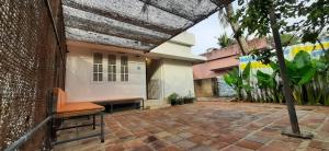 a patio with a chair and a brick building at a LoFT in Alleppey