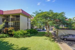 a yard in front of a house with a car at Airy Kailua-Kona Condo Less Than 1 Mi to Beach and Town in Kailua-Kona