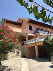 a house with balconies and flowers in front of it at Apartments Tartuga in Rab