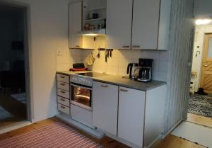 a kitchen with white cabinets and an oven at Saarijärvi - Omakotitalo, oma ranta in Kolkanlahti