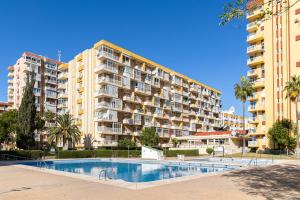 an apartment building with a swimming pool in front of it at Holidays2Arroyo de la Miel - Studios with terrace and Pool 800 mts from beach in Arroyo de la Miel
