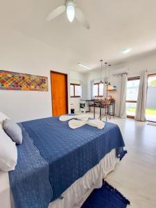a bedroom with a blue bed and a dining room at Suíte villa rota milagres, aconchegante & completa in São Miguel dos Milagres