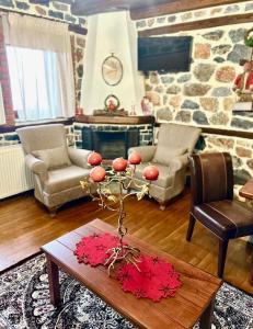 a living room with a table and a stone fireplace at ΑΝΑΛΗΨΗ in Palaios Agios Athanasios