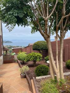 a garden with a tree and a patio at Casa vacacional A de Luisa in Bueu