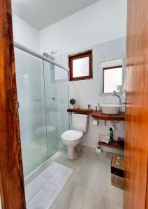 a bathroom with a toilet and a shower and a sink at Suíte villa rota milagres, aconchegante & completa in São Miguel dos Milagres