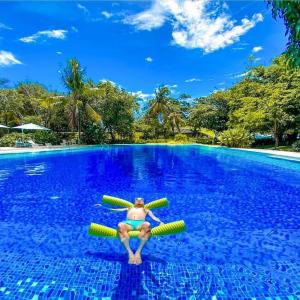 un hombre en una piscina en una balsa en el agua en Lovely Room en Maribago