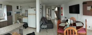 a kitchen and a living room with a table and a refrigerator at Apartamento con hermosa vista a 5 minutos del parque del café in Montenegro