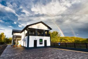 a house with a rainbow in the background at Holdruta Vendégház in Kunfehértó