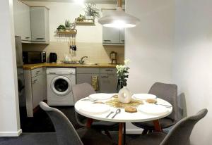 a kitchen with a table and chairs in a kitchen at Majestic Homes Heathrow - FREE PARKING in Stanwell