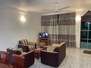 uma sala de estar com sofás e uma televisão de ecrã plano em Wonder Homestay em Negombo