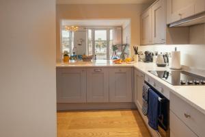 a kitchen with white cabinets and a sink at Harbour Living in Dartmouth