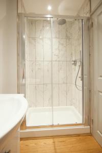 a bathroom with a shower with a white tub at Harbour Living in Dartmouth