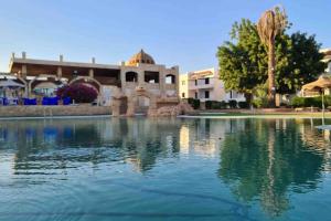 Riviera Resort Apartment - Pool view & Wifi في شرم الشيخ: تجمع كبير للمياه امام مبنى