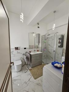 een witte badkamer met een douche en een wastafel bij La Finestra sul Porto in Genua