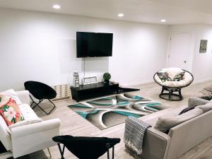 sala de estar con muebles blancos y TV de pantalla plana en Sunrise Paradise, en Camano