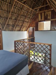 a bedroom with a bed in a straw hut at Gecko Hotel in El Paredón Buena Vista