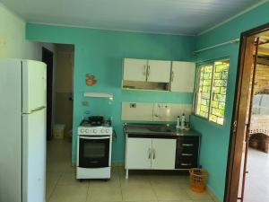 a kitchen with a white stove and a blue wall at Casas agradáveis, sossego e muita natureza. in Antonina