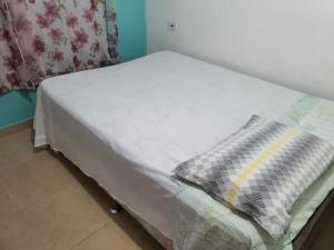- un lit avec un oreiller dans l'établissement Casa Vermelha Dois, à Antonina