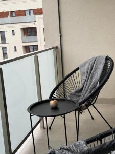 a black chair and a table on a balcony at Onix Residence in Baia Mare