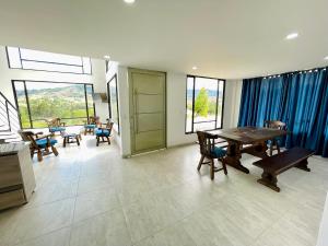 comedor con mesa, sillas y ventanas en CASA LUCE DI CIELO, en Tinjacá