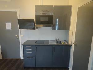 a small kitchen with a sink and a microwave at Oslo Airport Apartments in Gardermoen