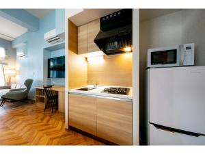 a kitchen with a white refrigerator and a microwave at VILLA KOSHIDO ODORI - Vacation STAY 04760v in Sapporo