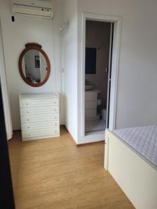 een slaapkamer met een spiegel en een witte dressoir bij Suíte com sala de estar in Lages