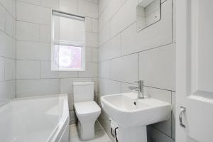 La salle de bains blanche est pourvue de toilettes et d'un lavabo. dans l'établissement Hornsey Lodge - Anfield Apartments, à Liverpool