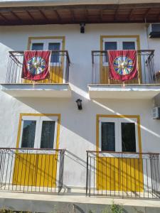ein Gebäude mit gelben Türen und roten Bannern auf den Balkonen in der Unterkunft Fazenda do Bosque - Pousada e Capril in Paraty