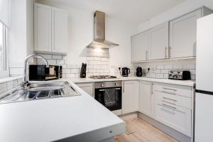 a kitchen with white cabinets and a white counter top at Hornsey Lodge - Anfield Apartments in Liverpool