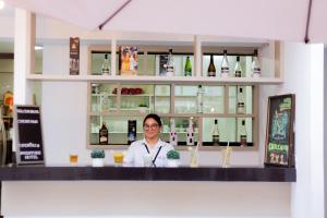 a man sitting behind a counter in a bar at Hotel Venture in Chincha Alta