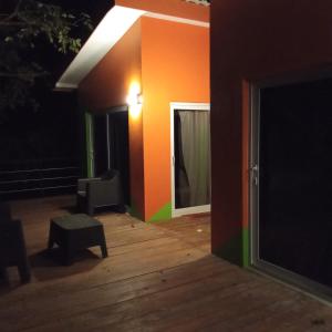 Zimmer mit orangefarbener Wand, Stuhl und Tisch in der Unterkunft Cabañas LuMa in Guanteque