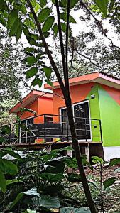 een kleurrijk huis wordt gezien door de bomen bij Cabañas LuMa in Guanteque
