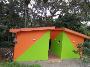 une petite maison avec des tons orange et vert dans l'établissement Cabañas LuMa, à Guanteque