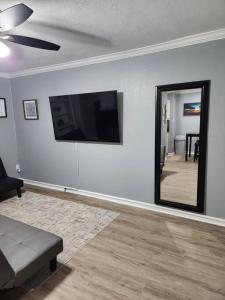 een woonkamer met een bank en een spiegel bij Blue Shark *E19* @ Midtown Functional 1BR King Apartment in Houston