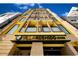 un edificio alto amarillo con un cartel en él en VILLA KOSHIDO ODORI - Vacation STAY 04752v, en Sapporo