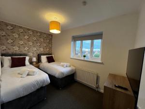 um quarto de hotel com duas camas e uma janela em Frensham House em Dallington