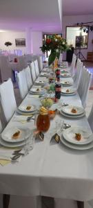 a long white table with plates of food on it at Hotel Piast in Myślibórz