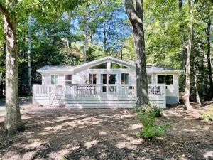 Ein weißes Haus mitten im Wald in der Unterkunft Cozy Ocean Pines Cottage in Ocean Pines