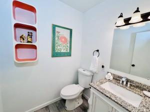 ein Badezimmer mit Toilette, Waschbecken und Spiegel in der Unterkunft Cozy Ocean Pines Cottage in Ocean Pines + 26 Fotos