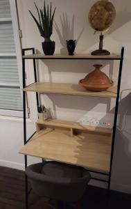 a shelf with various items on it in a room at T2 Cosy autonome h24 Parking privé attenant TV 165cm Netflix wi-fi au Rez-de-chaussée in Alençon +1 photo