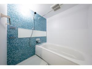 ein Badezimmer mit einer Dusche und einer weißen Badewanne in der Unterkunft VILLA KOSHIDO ODORI - Vacation STAY 04767v in Sapporo